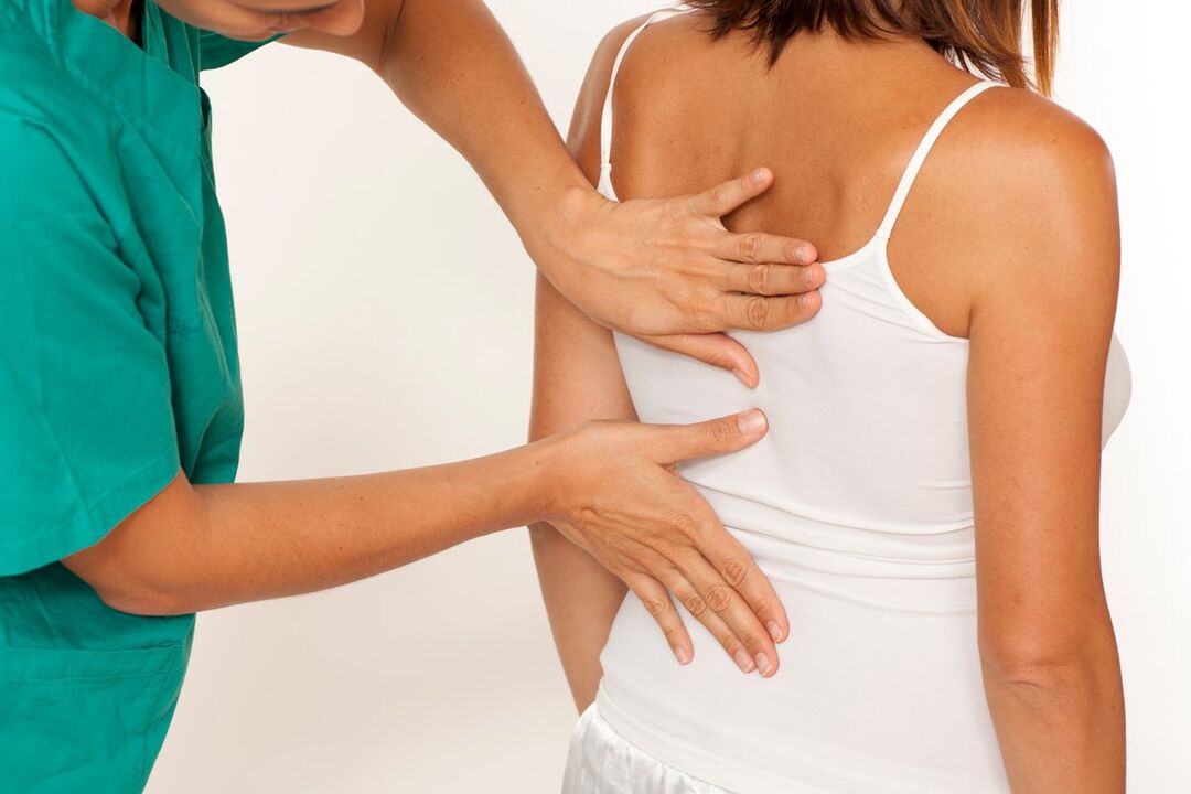 the doctor examines the back for pain in the shoulder blade